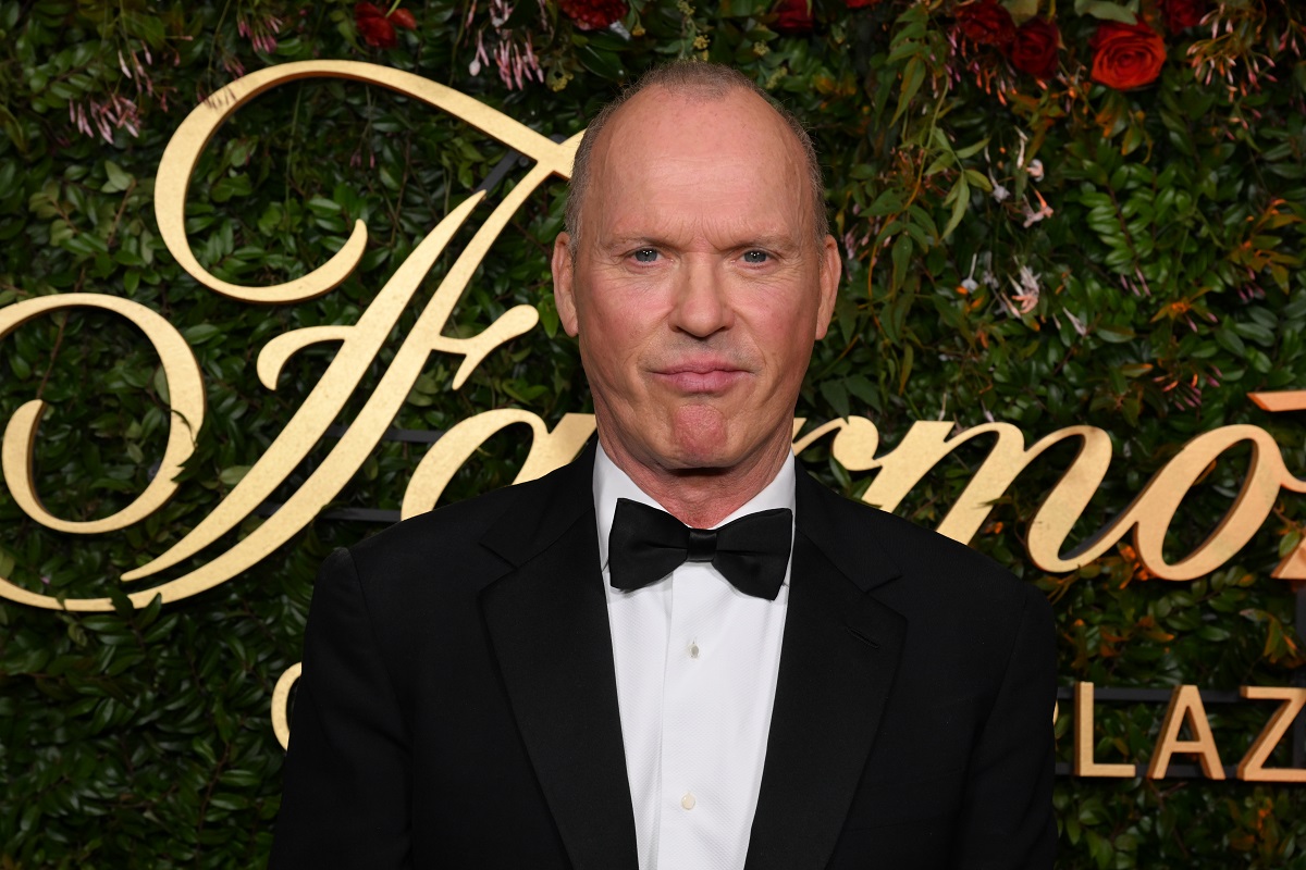 Michael Keaton posant en portant un costume.