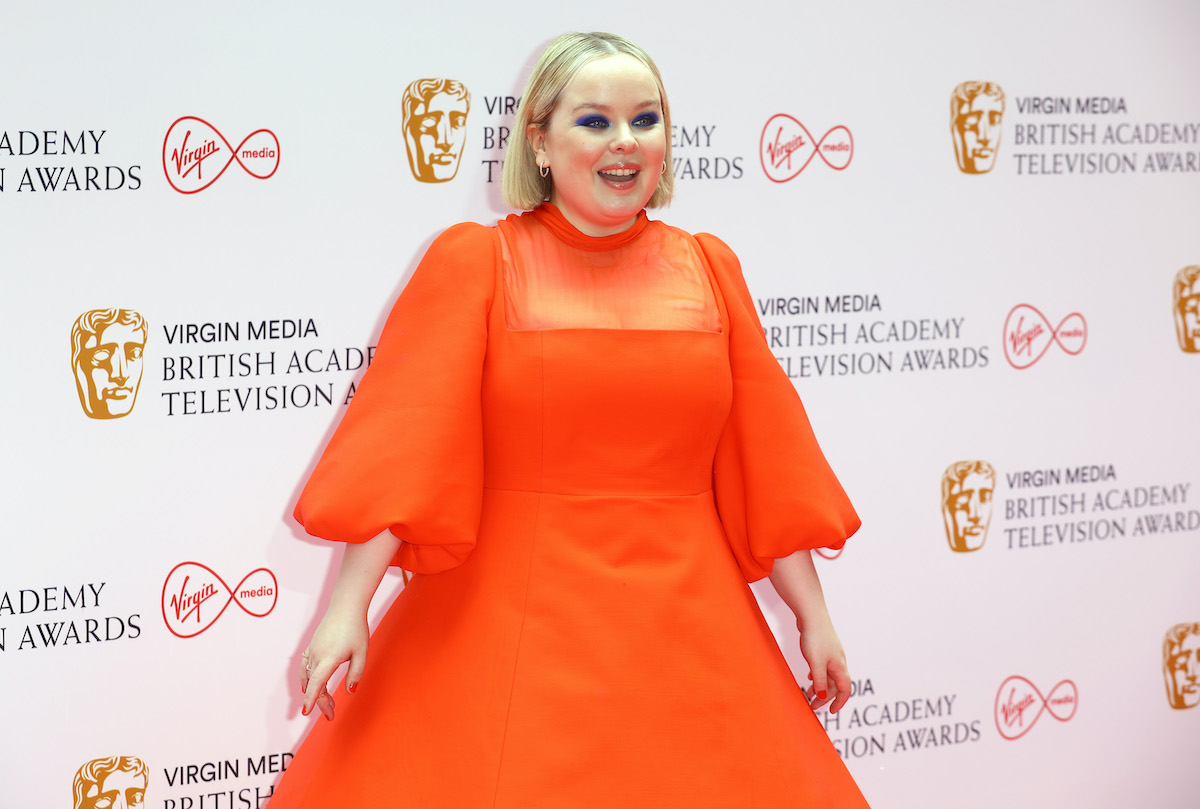 Nicola Coughlan souriant devant un fond blanc