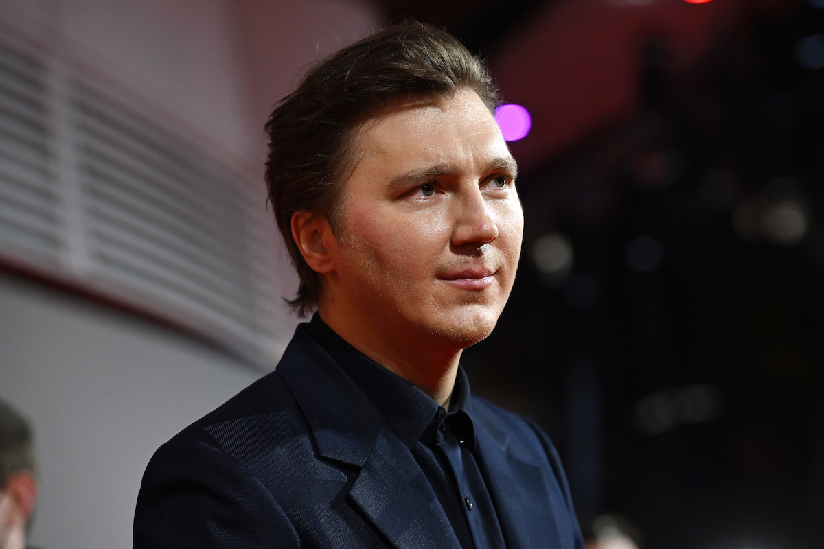Paul Dano porte un costume et pose sur le tapis rouge