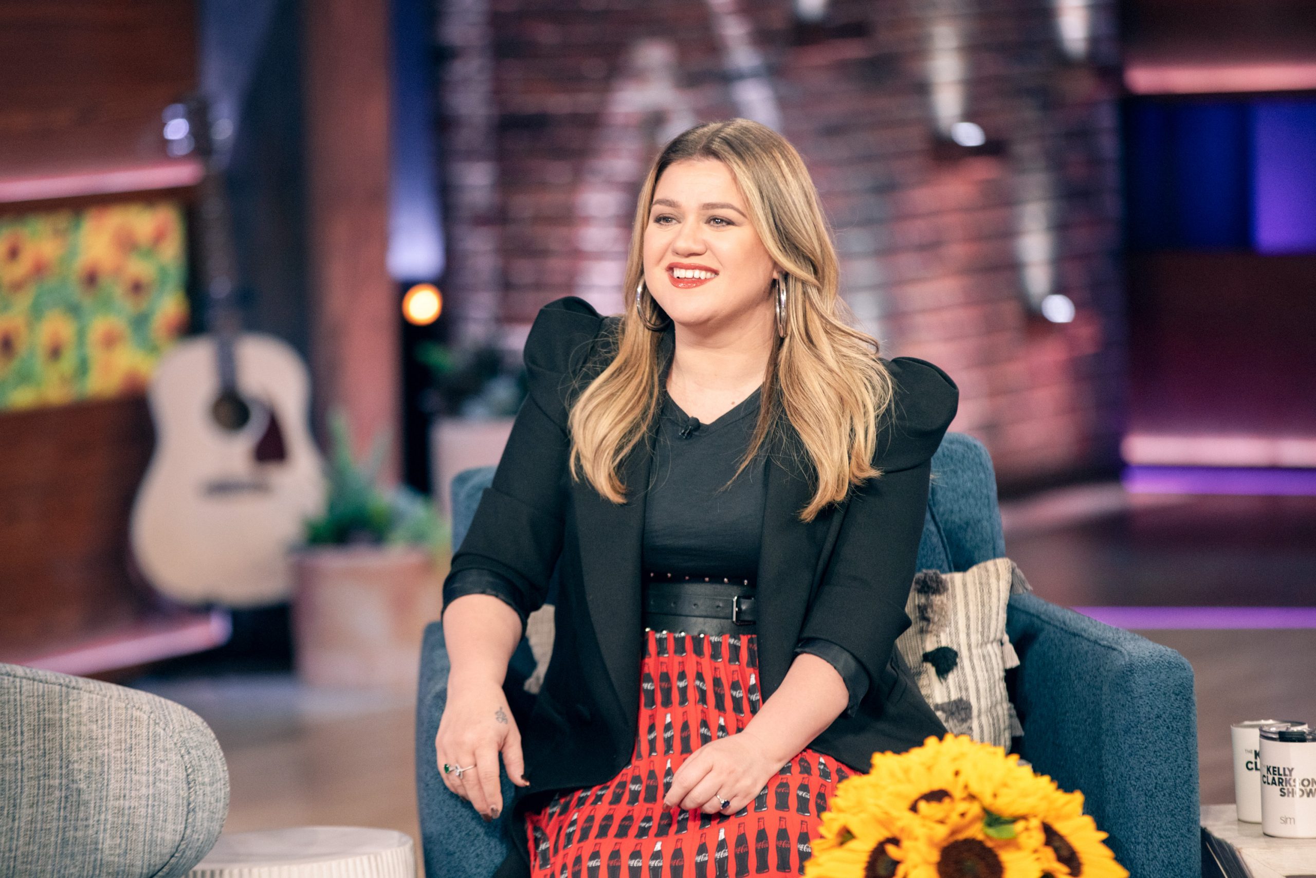 Kelly Clarkson assise sur le plateau de son talk-show