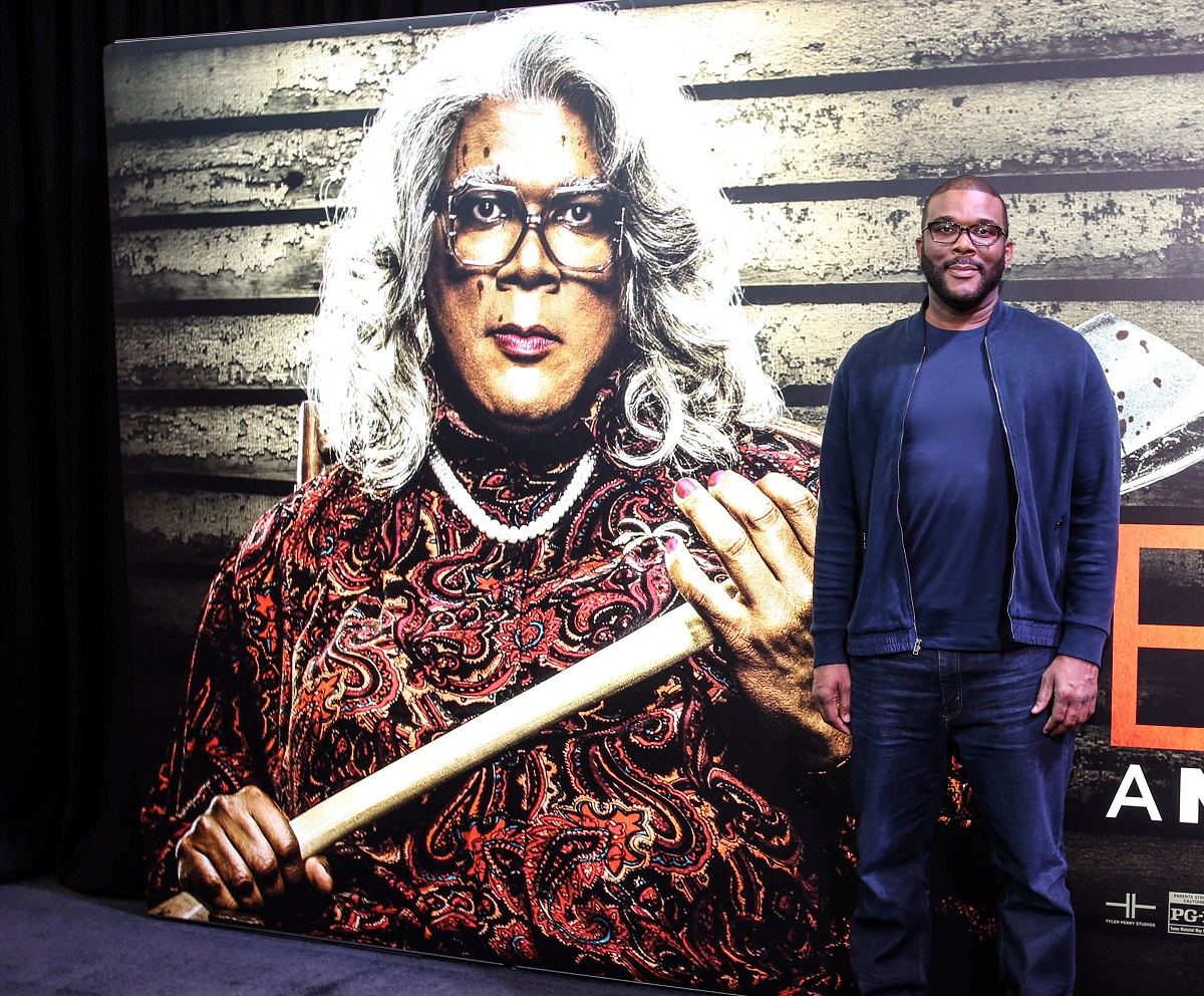 Tyler Perry sur le tapis rouge à côté de l'affiche de Madea lors de la projection de Boo ! Un Halloween fait à la main