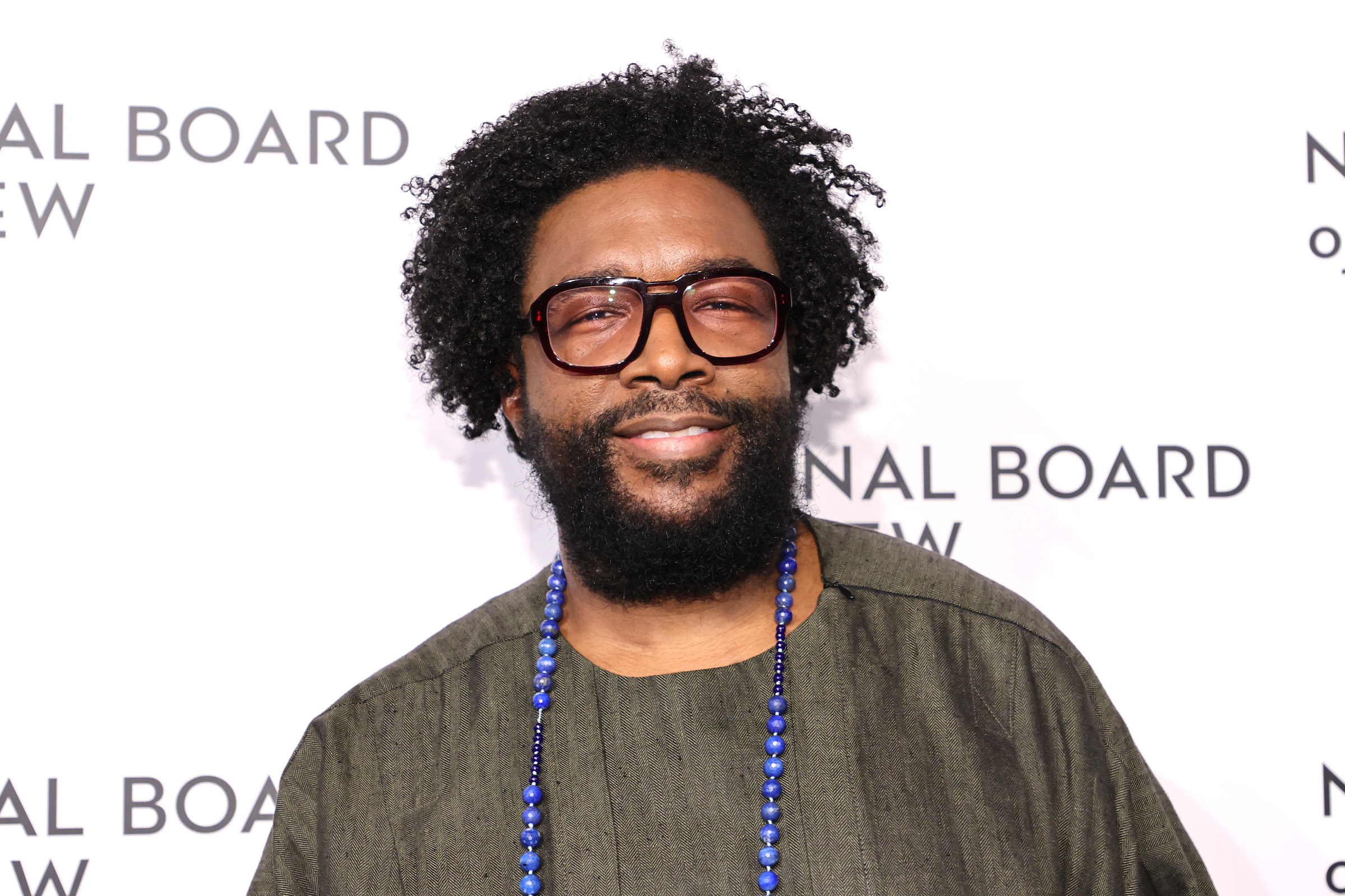 Ahmir "Questlove" Thompson souriant sur fond blanc
