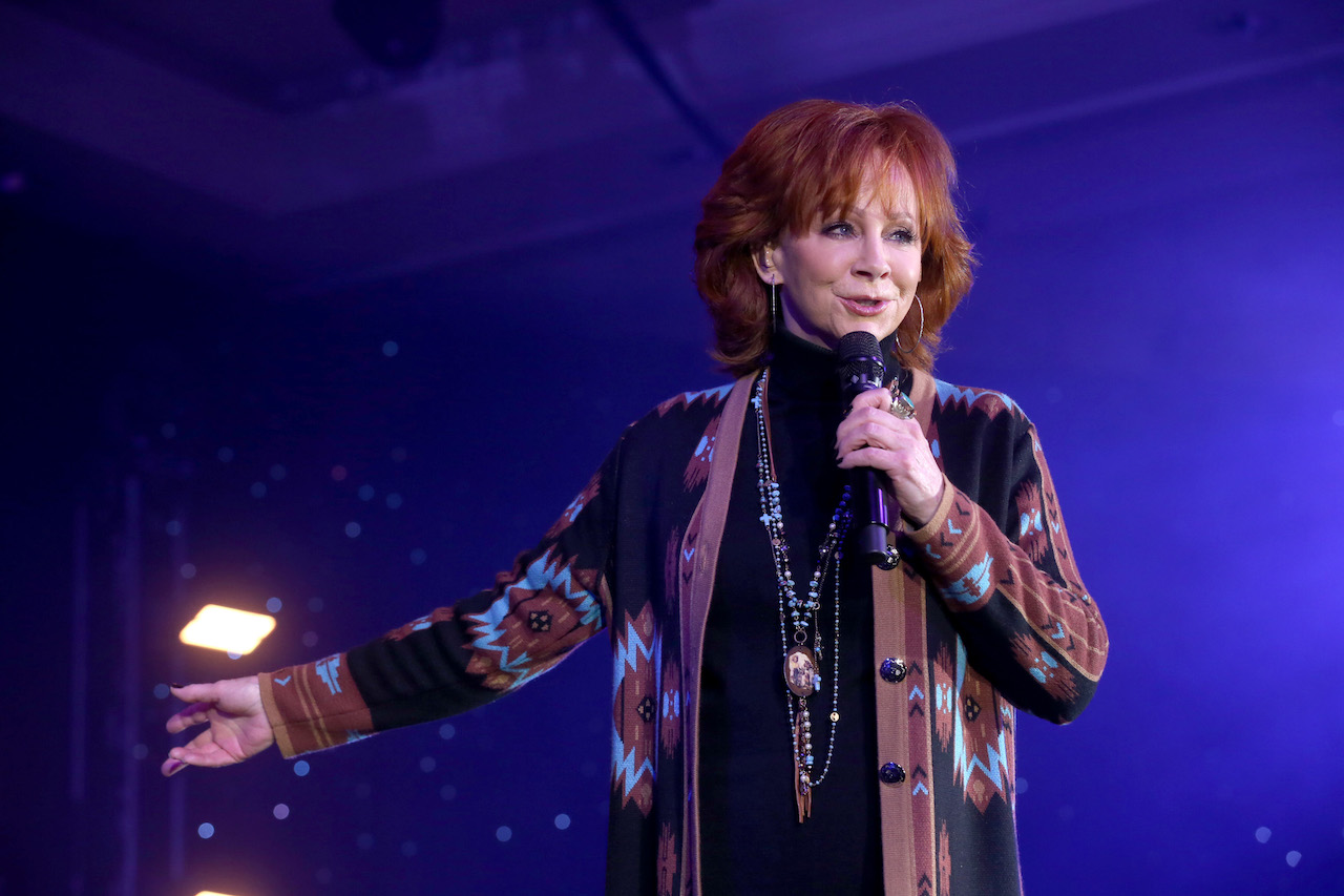 Reba McEntire se produit sur scène dans un cardigan imprimé et des colliers suspendus