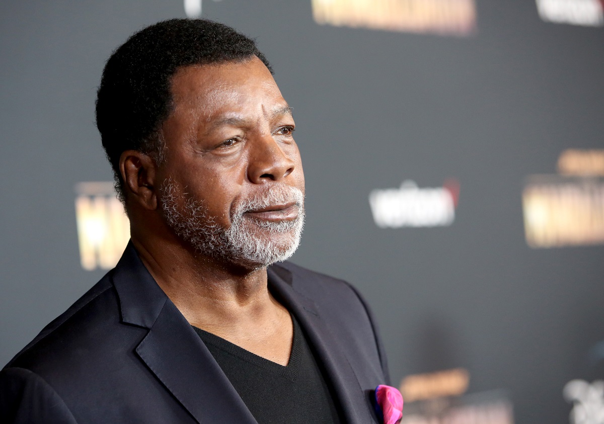 Carl Weathers sourit en portant un costume.