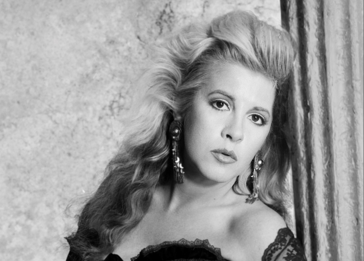 Une photo en noir et blanc de Stevie Nicks portant une chemise en dentelle et appuyé contre un pilier.
