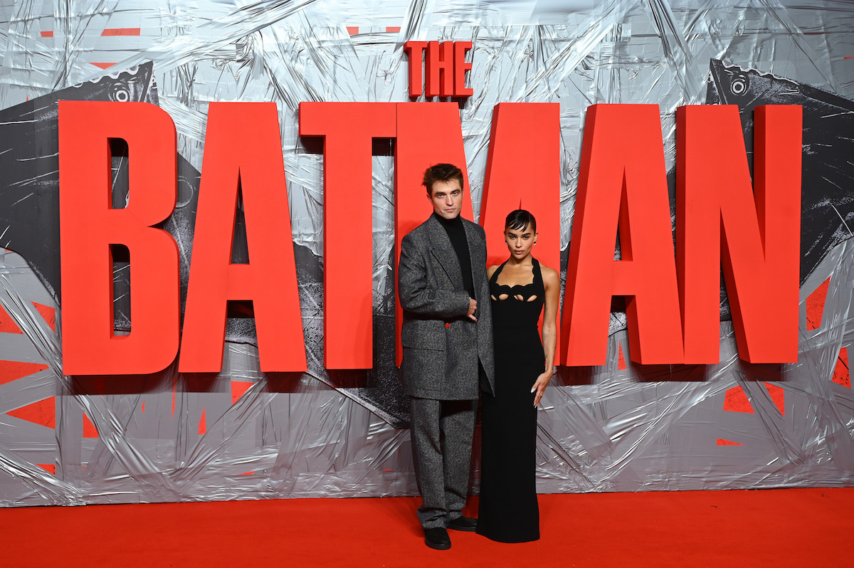 Robert Pattinson et Zoe Kravitz posent devant un grand panneau rouge qui dit "The Batman".