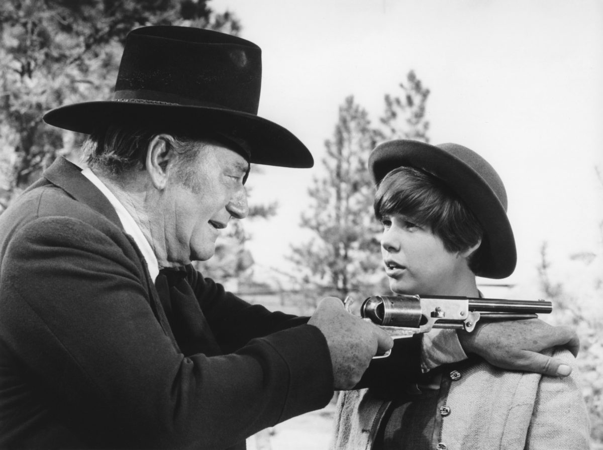 'True Grit' John Wayne dans le rôle de Rooster Cogburn et Kim Darby dans le rôle de Mattie Ross se regardant avec Wayne tenant un pistolet sur son épaule