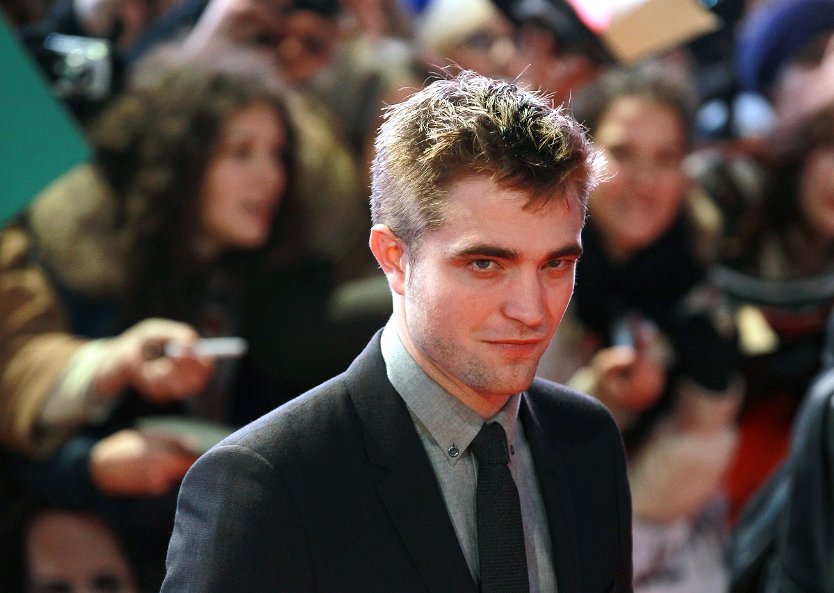 Robert Pattinson souriant en portant un costume.