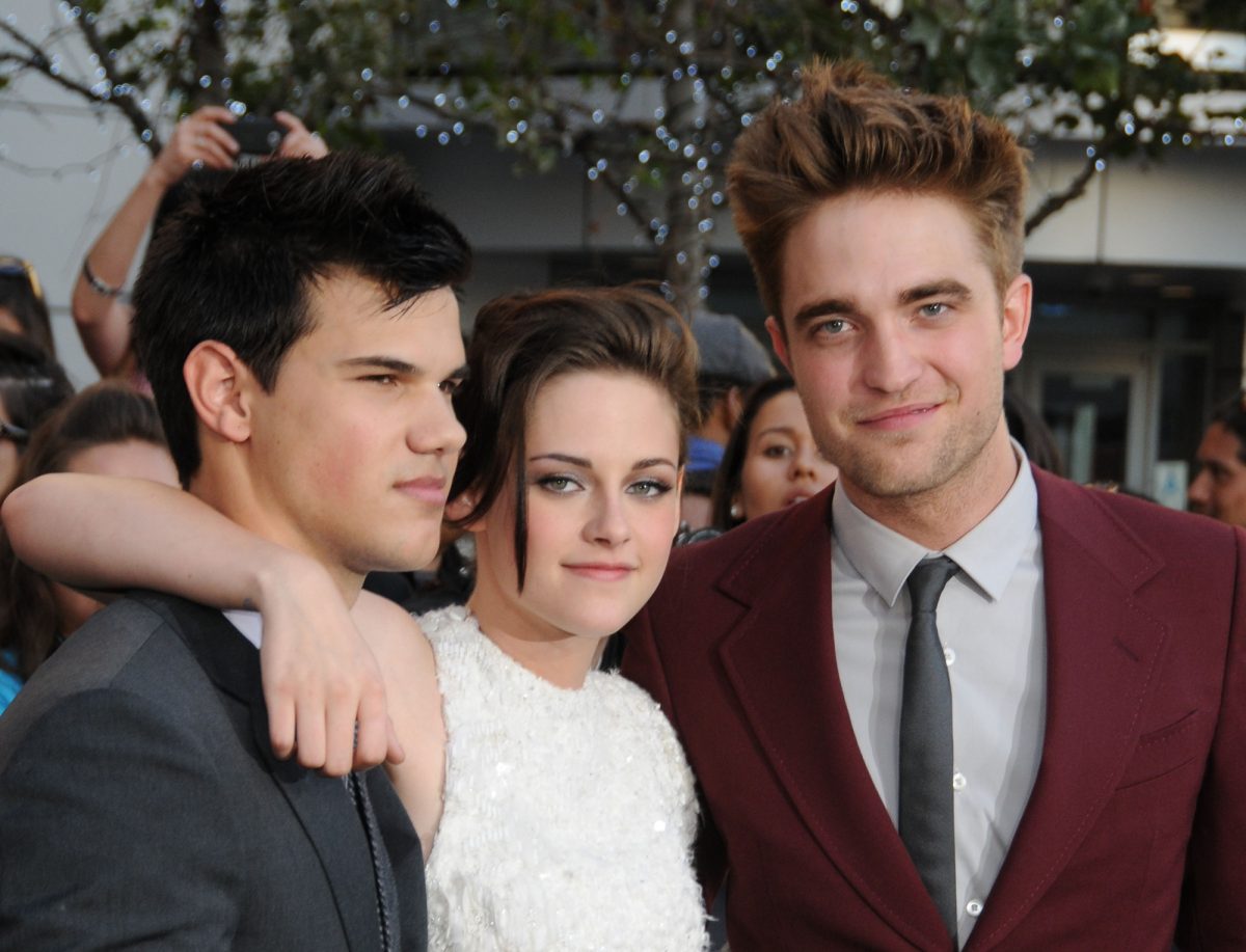 'Twilight' Taylor Lautner, Robert Pattinson et Kristen Stewart, qui joue Bella dans la maison Swan en tenue formelle avec des gens qui prennent des photos en arrière-plan