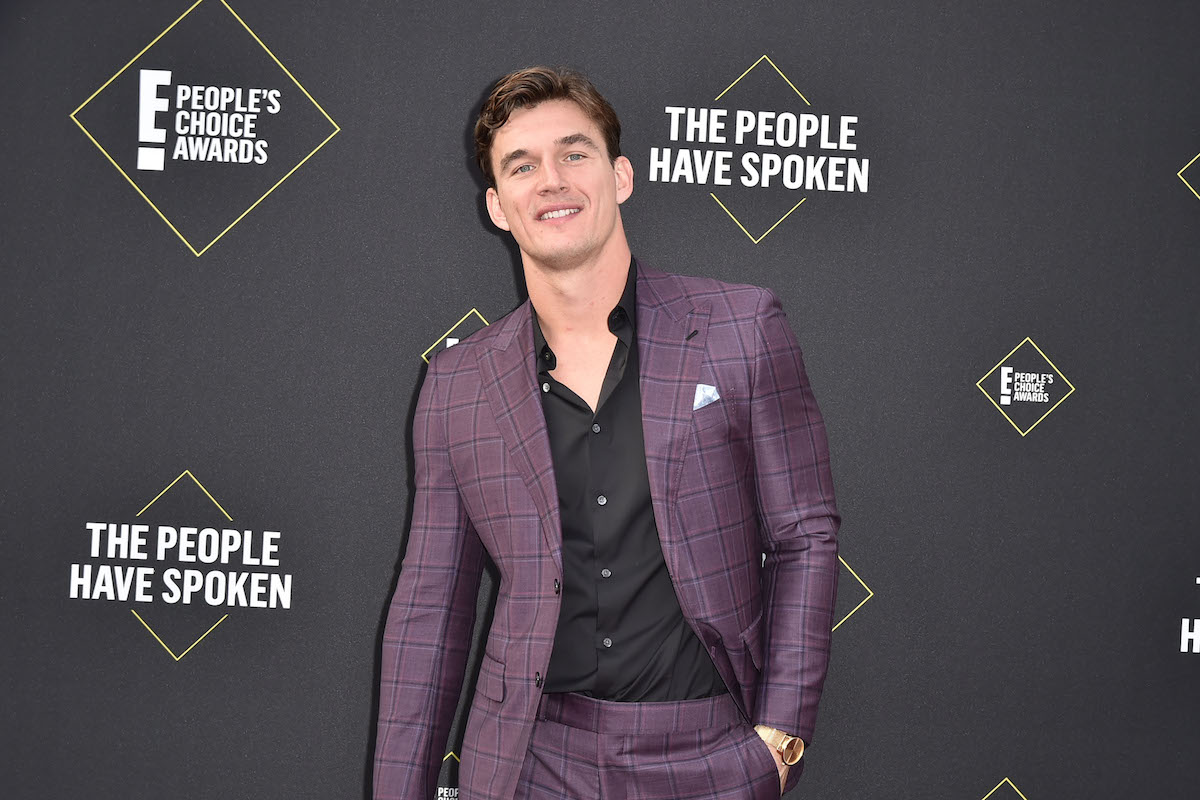 Tyler Cameron souriant devant un fond noir