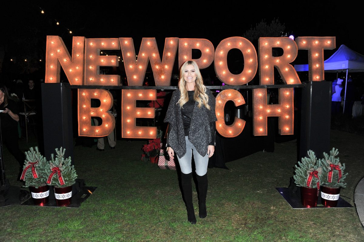 Christina Haack souriant devant un panneau Newport Beach la nuit