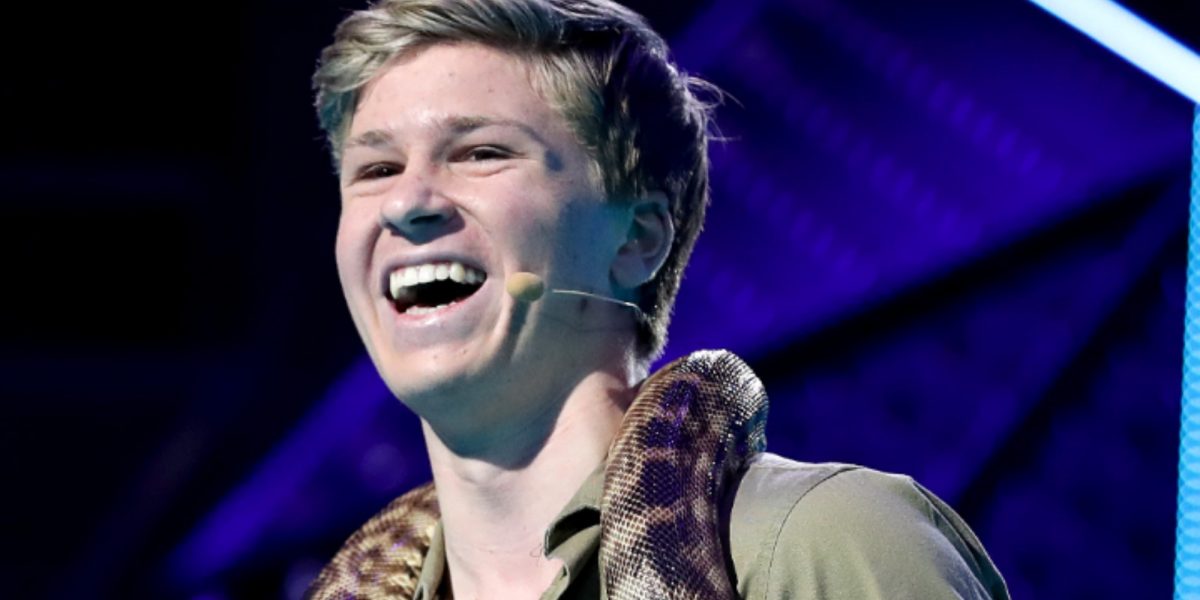 Robert Irwin pose avec un serpent autour du cou.