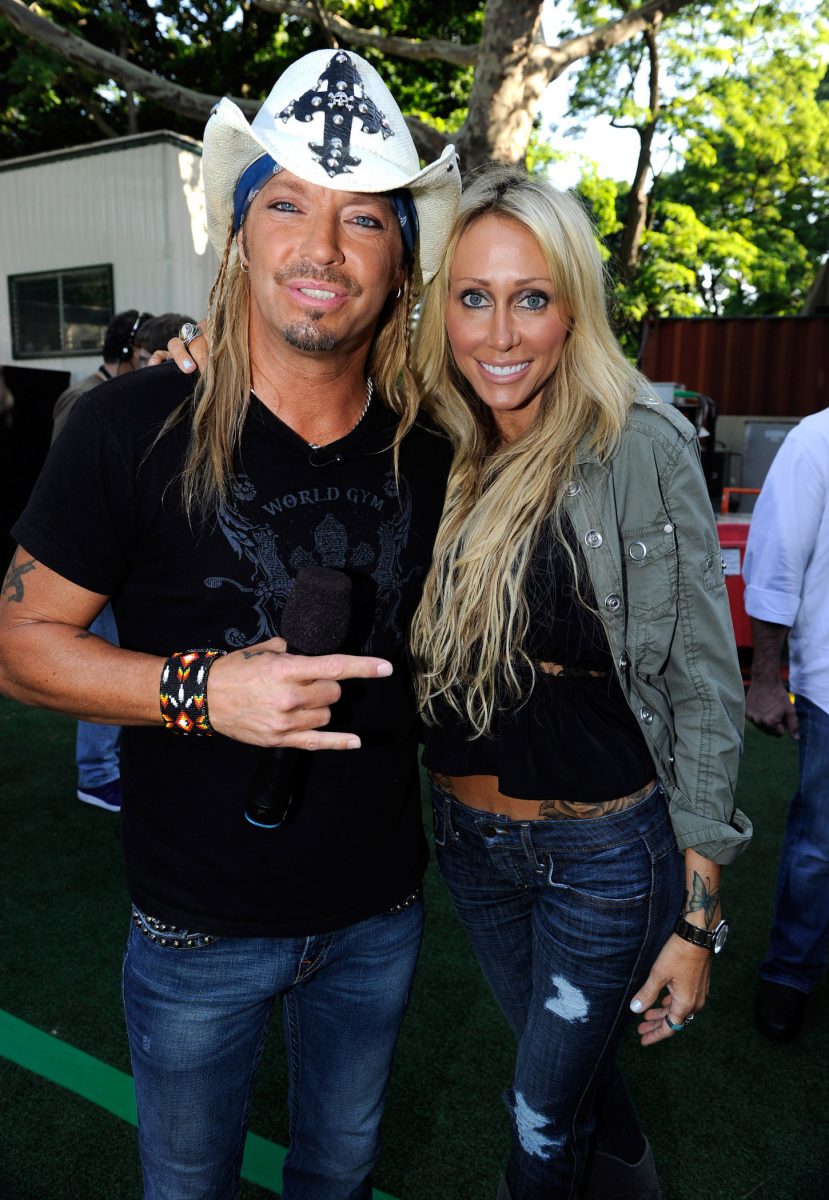 Bret Michaels et Tish Cyrus debout, les bras l'un autour de l'autre et souriant pour une photo
