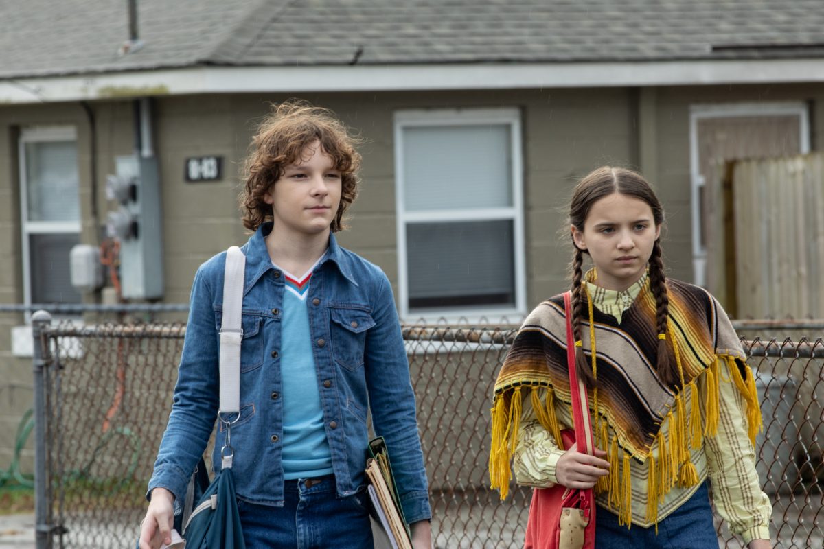 'The Black Phone' Mason Thames dans le rôle de Finney Shaw et Madeleine McGraw dans le rôle de Gwen Shaw tenant leurs sacs sur leurs épaules devant une maison en banlieue