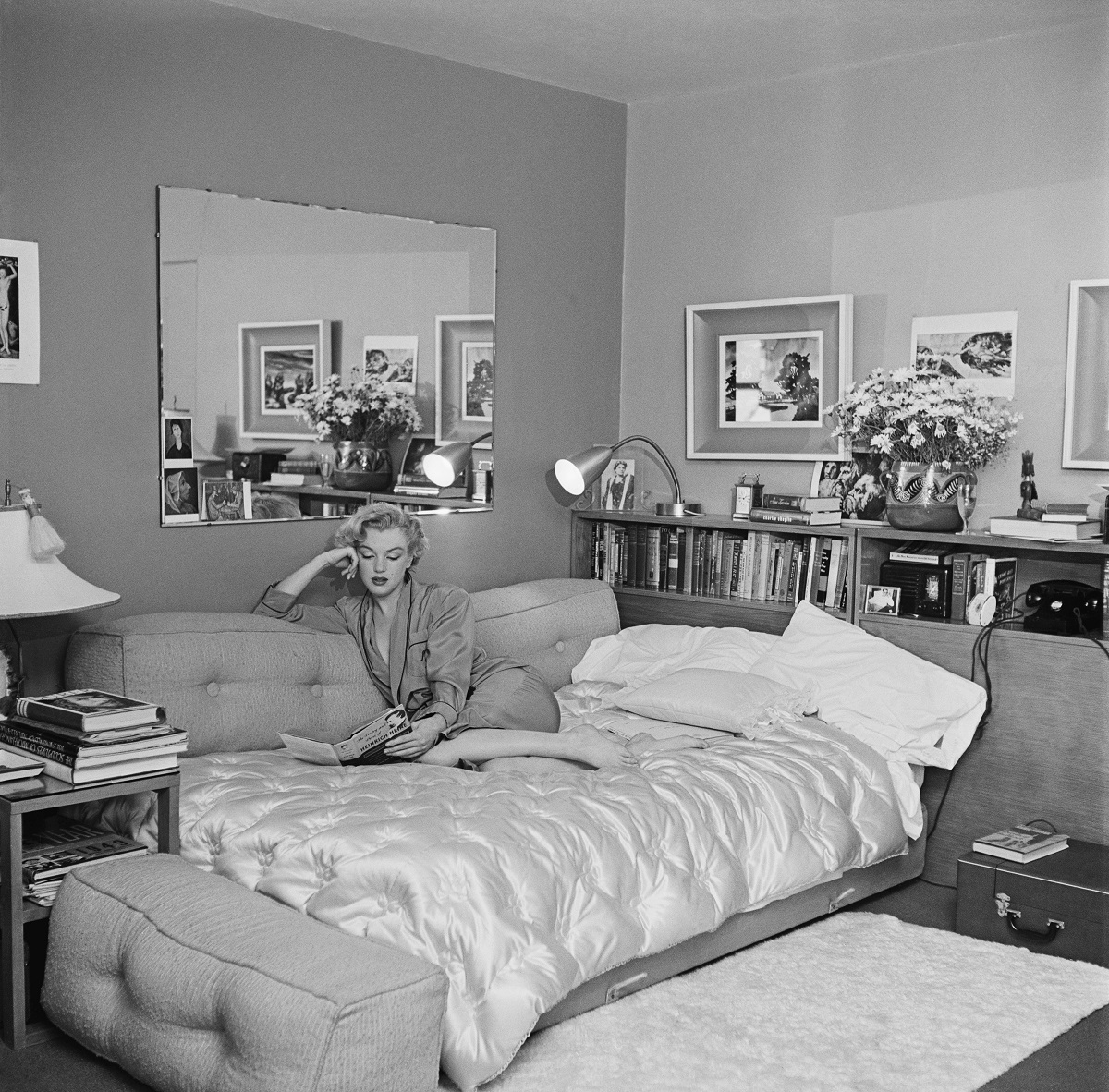 Marilyn Monroe vue en train de lire sur un canapé-lit vers 1951