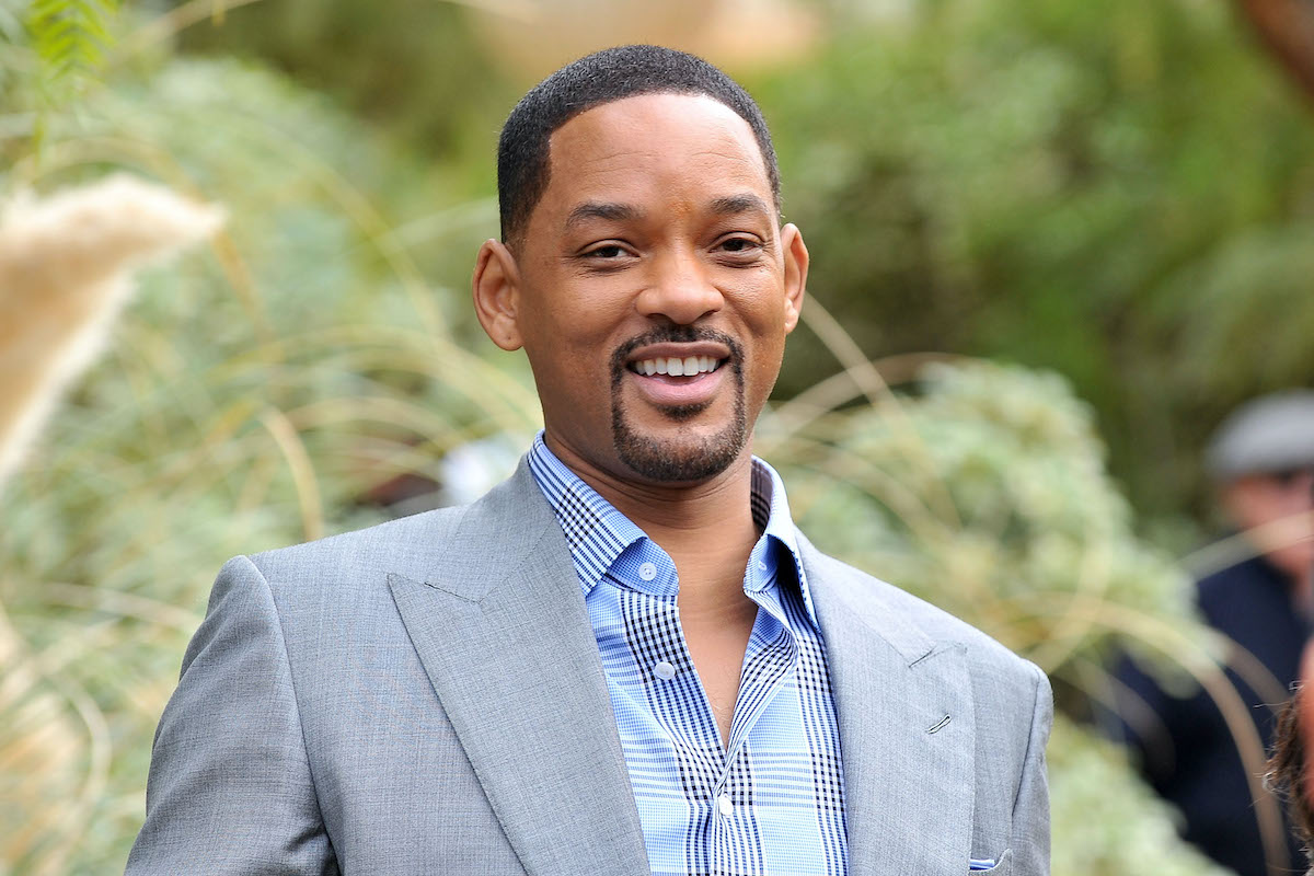 Will Smith sourit dans un costume gris