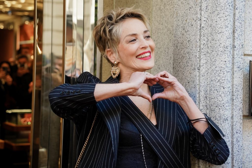 Sharon Stone, propriétaire de la même maison à Los Angeles depuis des décennies, fait un geste du cœur devant la boutique Dolce & Gabbana pendant la Fashion Week de Milan