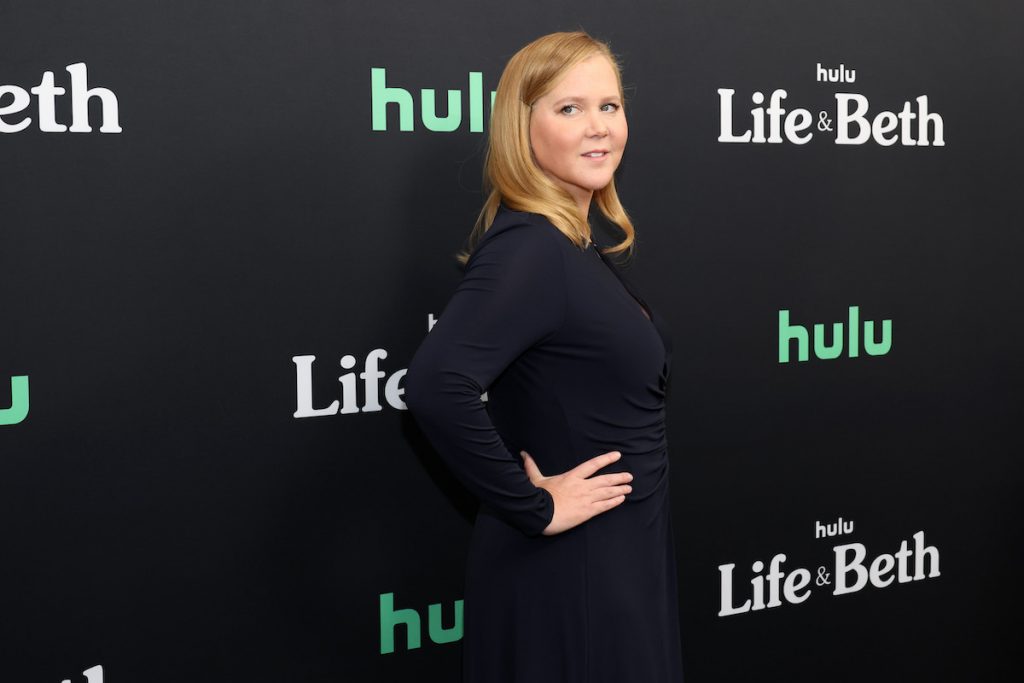 Amy Schumer pose dans une robe noire à l'avant-première de