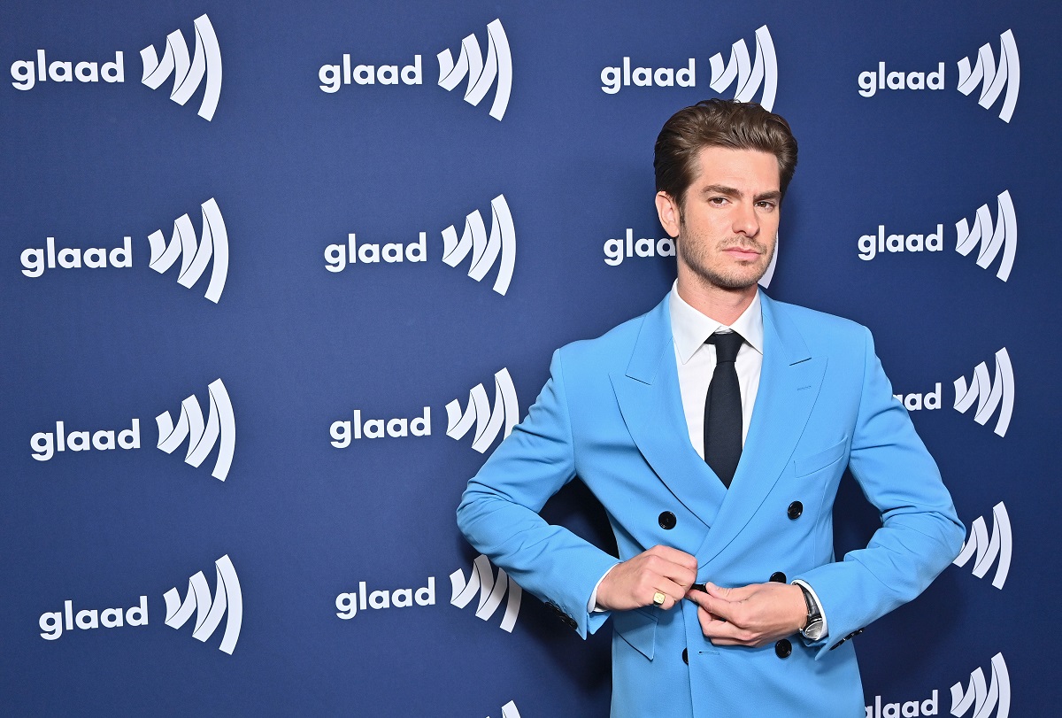 Andrew Garfield posant tout en portant un costume bleu.