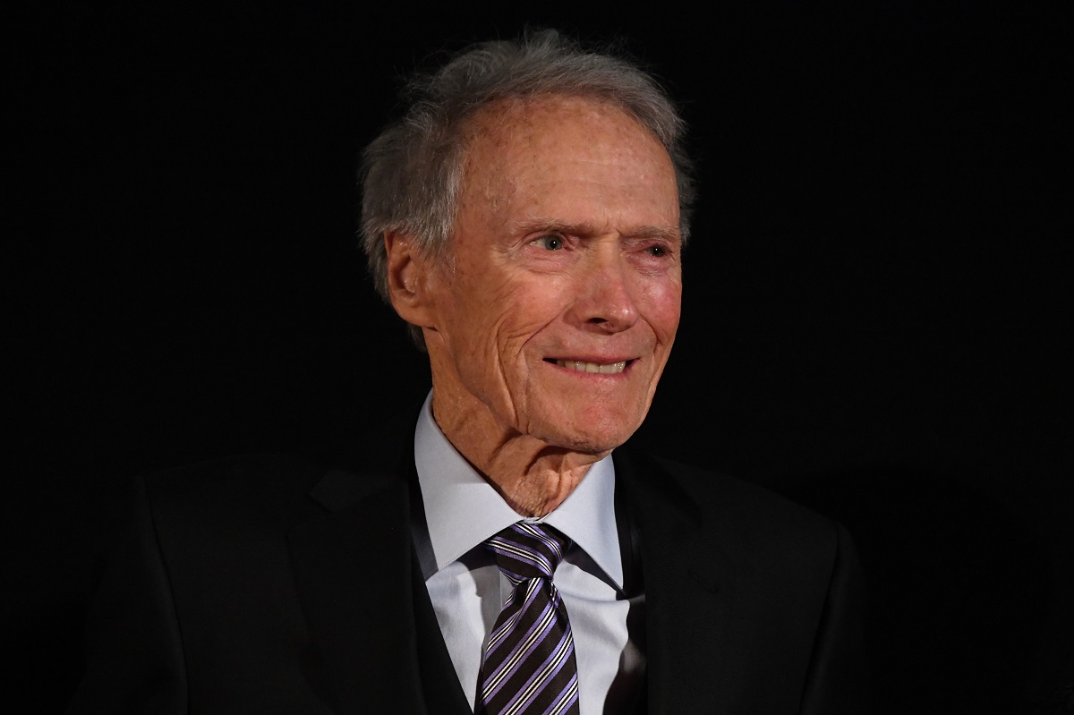 Clint Eastwood souriant tout en portant un costume.