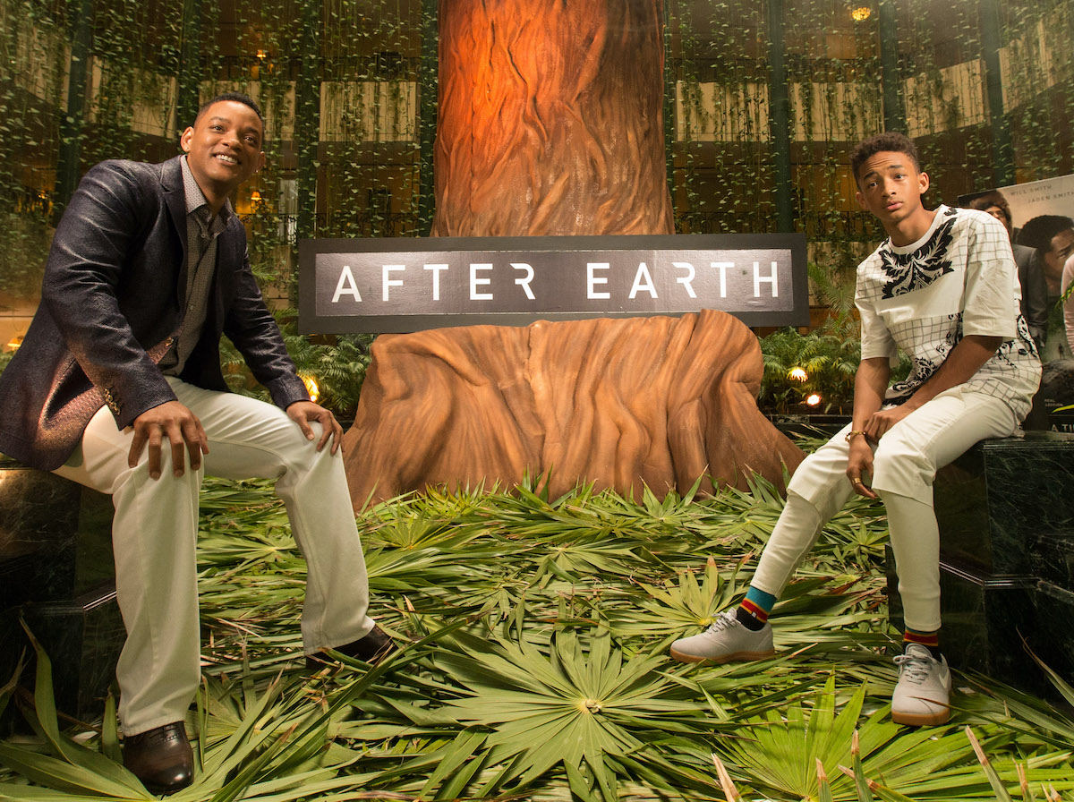Will Smith et Jaden Smith posent devant sur un arrière-plan sur le thème de leur film 