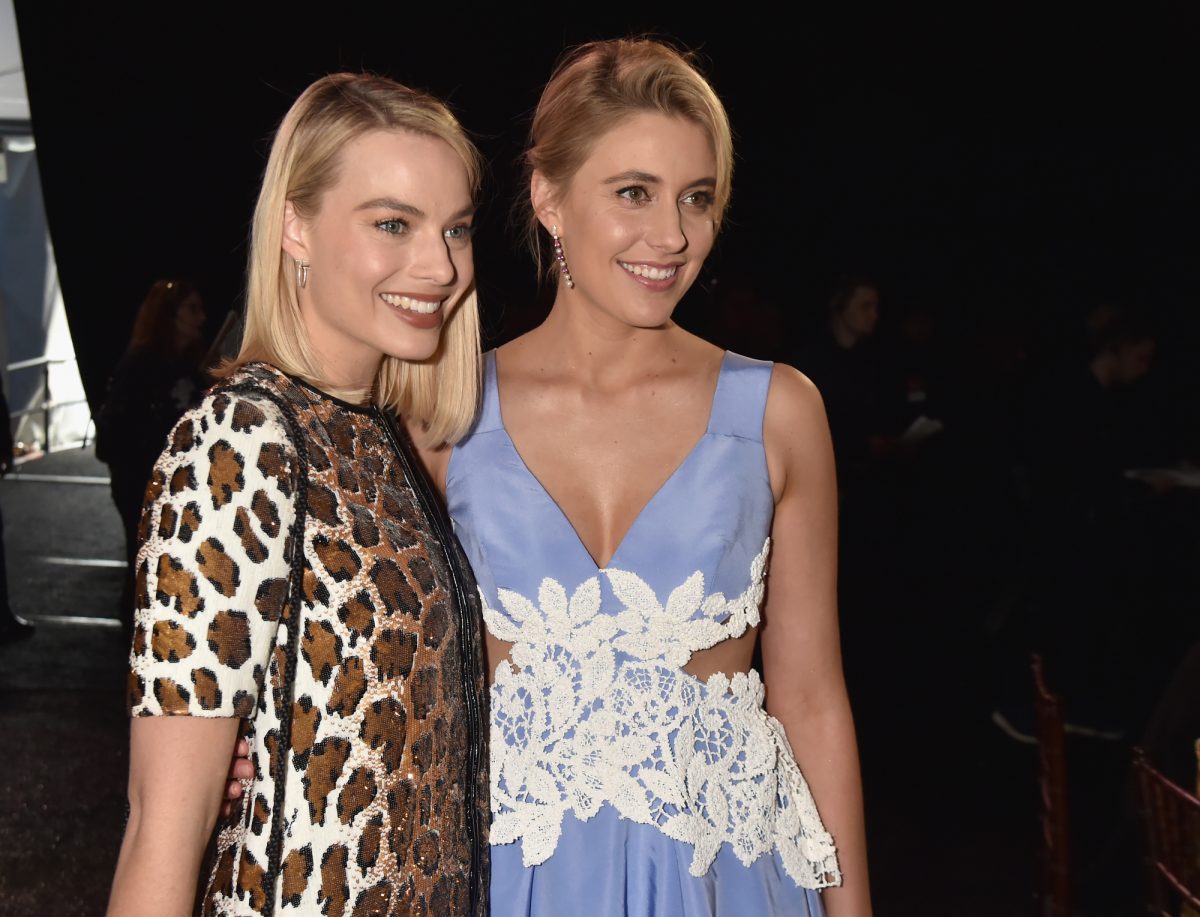 L'acteur 'Barbie' Margot Robbie et la cinéaste Greta Gerwig debout portant une robe à imprimé léopard et une robe bleue avec un bras l'un autour de l'autre