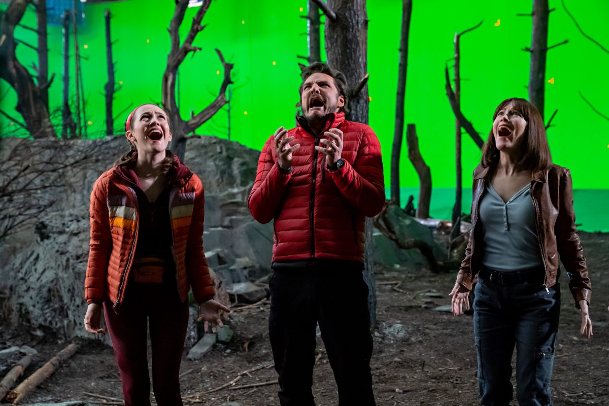 'The Bubble' Iris Apatow dans le rôle de Krystal Kris, Pedro Pascal dans le rôle de Dieter Bravo et Leslie Mann dans le rôle de Lauren Van Chance hurlant sur un décor de film forestier avec un écran vert derrière eux