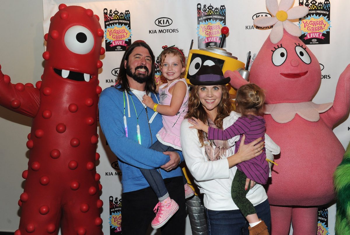 Dave Grohl tenant sa fille et posant avec sa famille au 'Yo Gabba Gabba' Live en 2010.