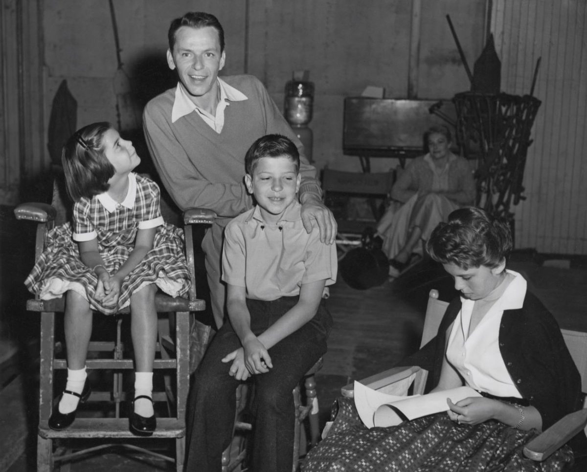 Une photo en noir et blanc de Frank Sinatra avec ses enfants, Tina, Frank et Nancy. 