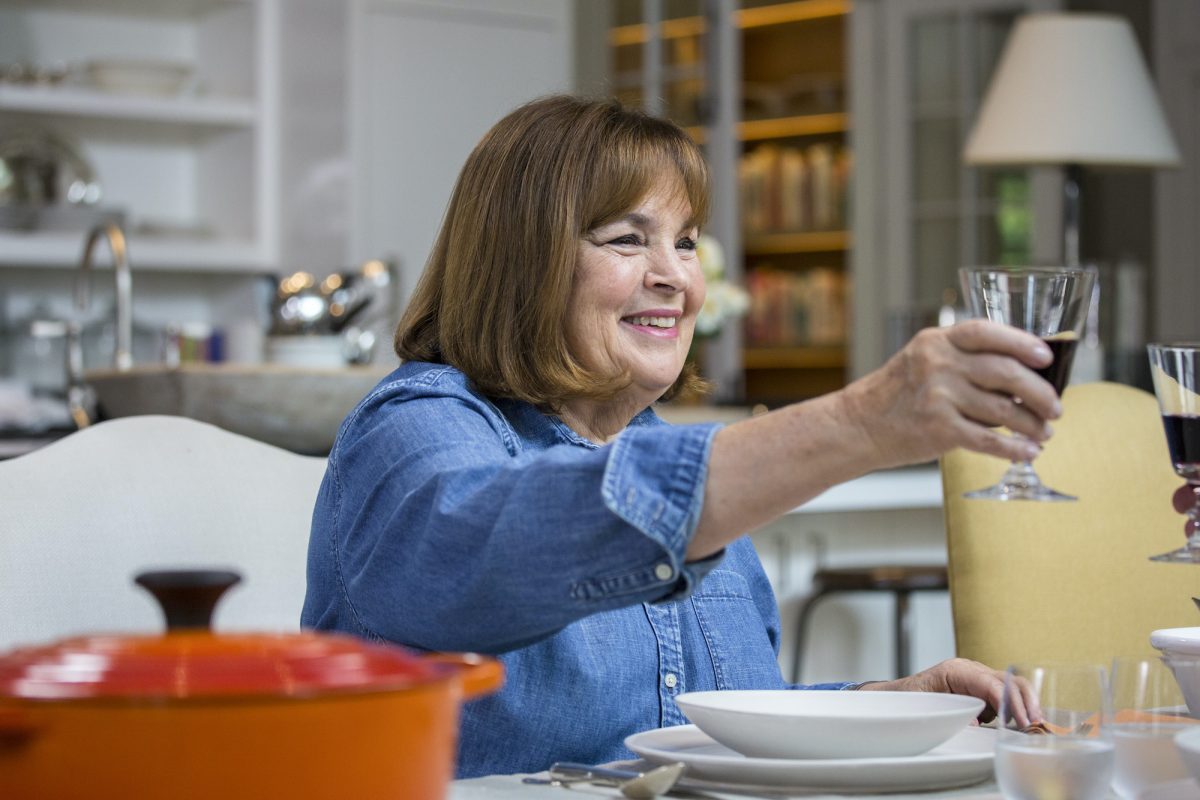 Ina Garten porte une chemise bleue tout en souriant et en portant un toast avec un verre de vin