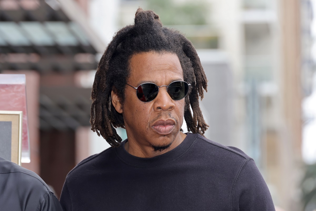 Jay-Z posant avec des lunettes de soleil et un t-shirt noir.