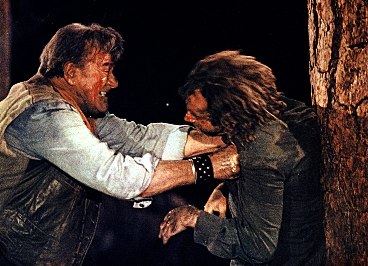 'The Cowboys' John Wayne dans le rôle de Wil Andersen et Bruce Dern dans le rôle d'Asa Watts (cheveux longs) se battant brutalement contre un arbre