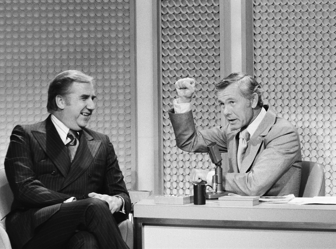 Ed McMahon est assis à côté de Johnny Carson au bureau du Tonight Show en 1972, alors que Carson en lève un premier dans les airs comme s'il frappait
