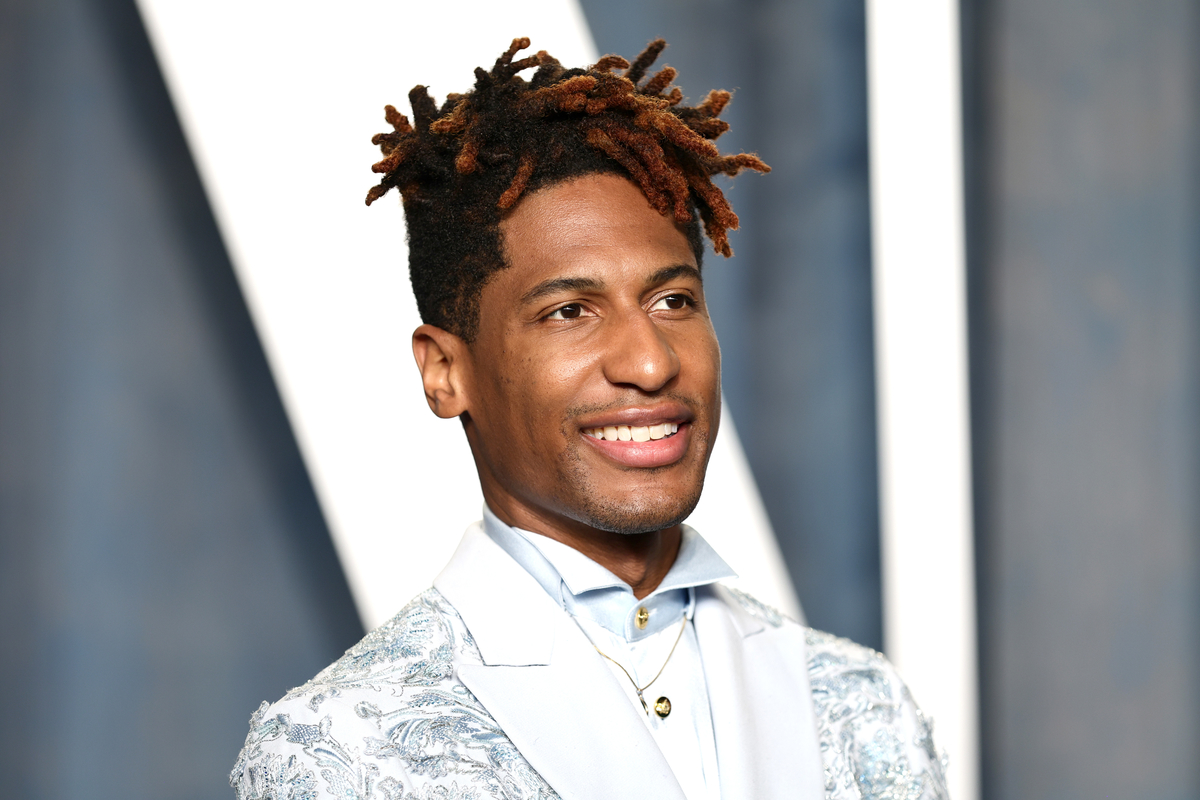Jon Batiste portant un costume bleu clair et posant pour une photo à la soirée Vanity Fair Oscar à Beverly Hills, CA.