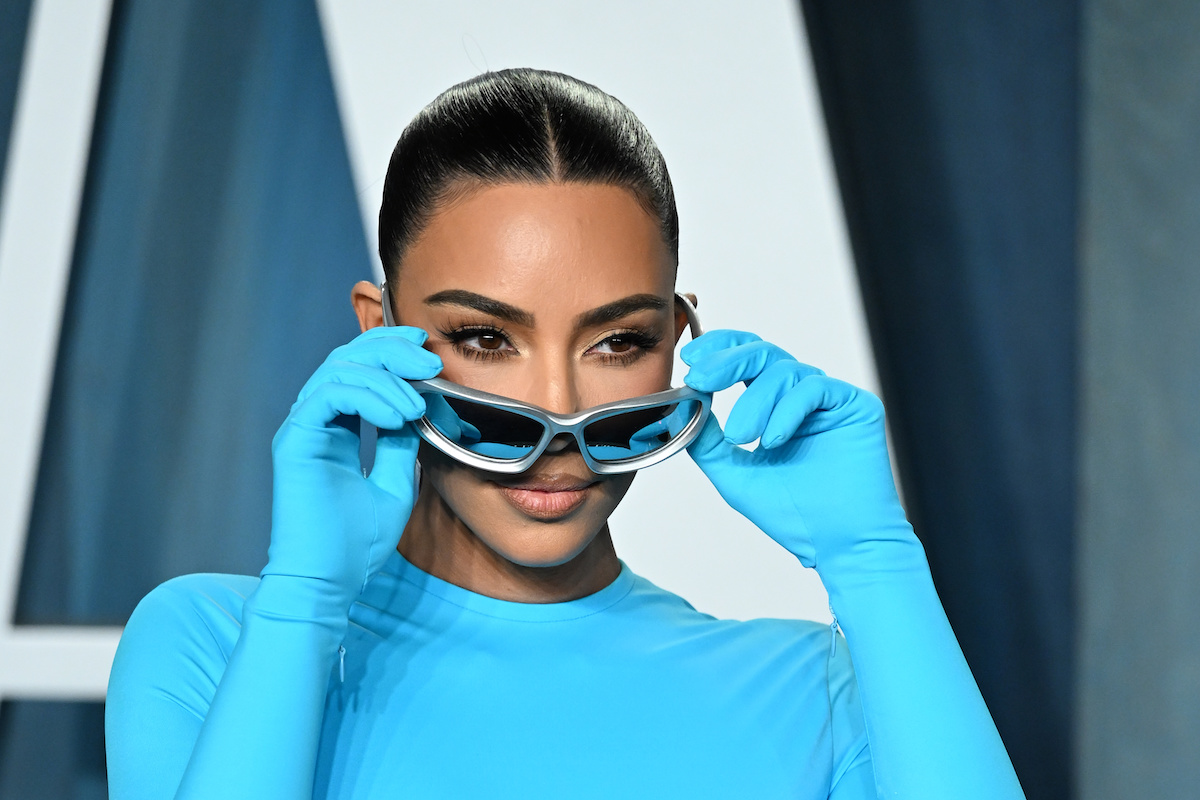 Kim Kardashian met une paire de lunettes de soleil lors d'un événement.