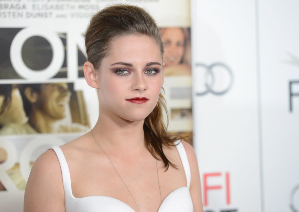 L'actrice Kristen Stewart pose pour les caméras tout en portant un haut blanc et du rouge à lèvres lors de la première de 