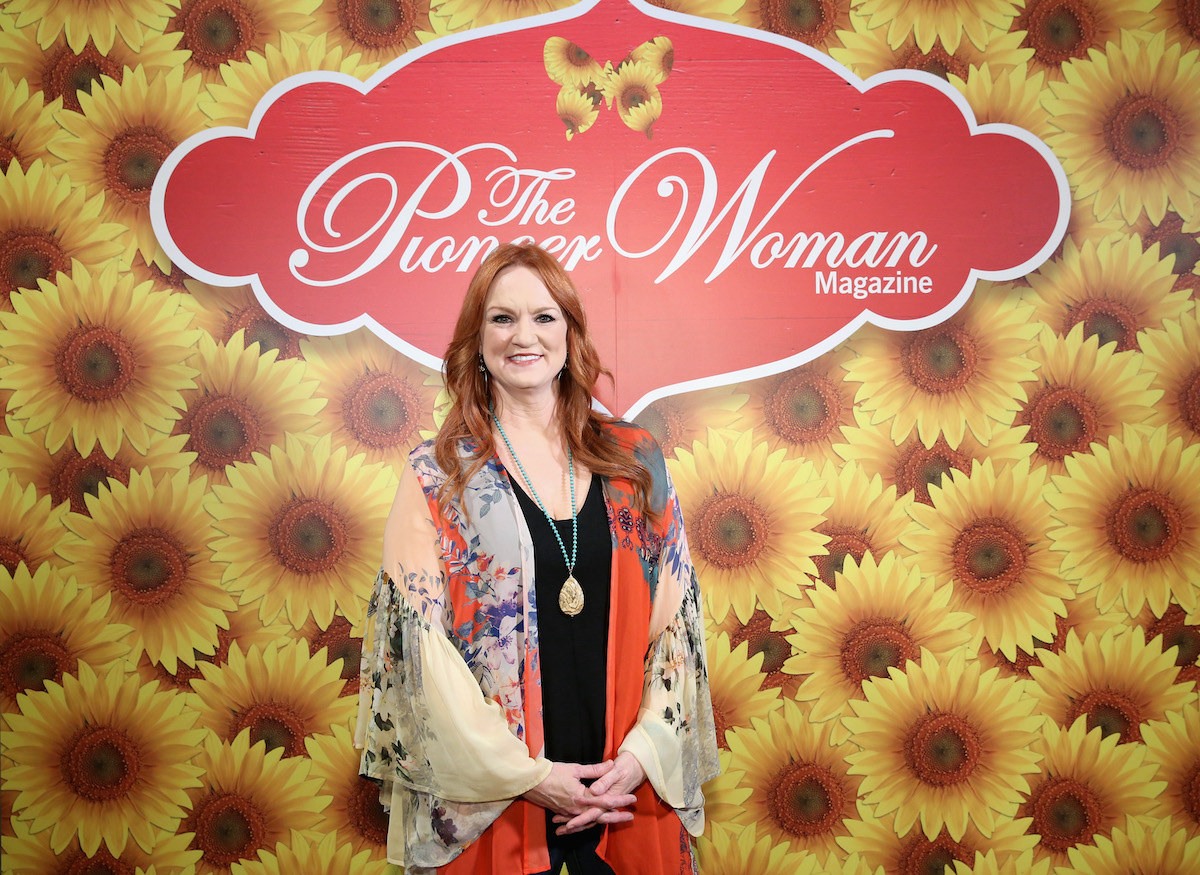 Ree Drummond porte un haut multicolore devant un mur de tournesol sur lequel on peut lire 