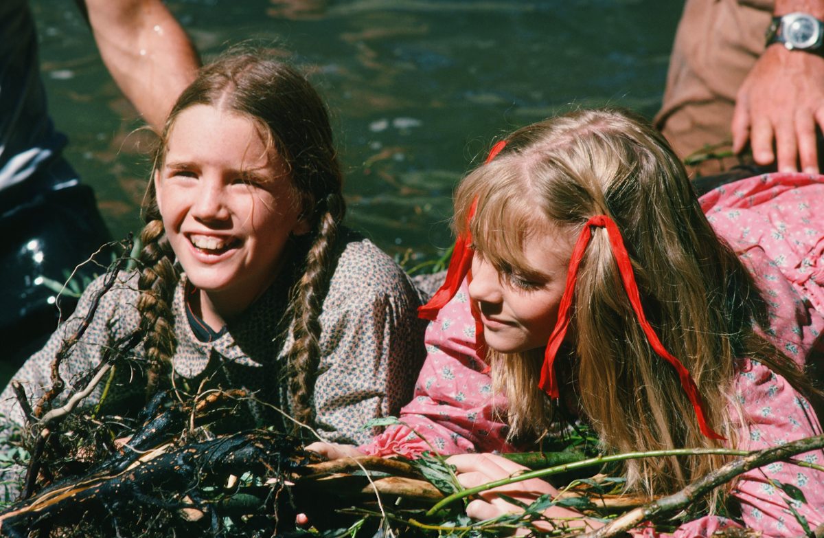 Melissa Gilbert et Alison Arngrim sourient en filmant une scène de rivière sur le tournage de La Petite Maison dans la Prairie.