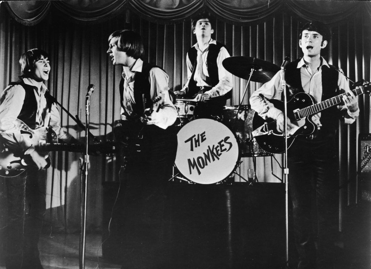 Davy Jones, Peter Tork, Micky Dolenz et Mike Nesmith des Monkees devant un rideau