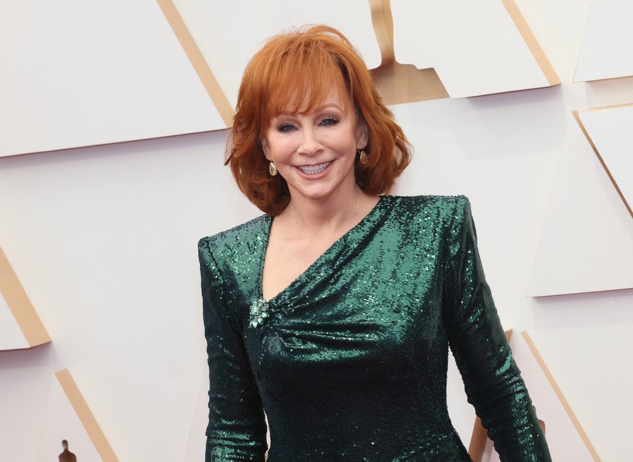 Reba McEntire dans une robe vert foncé scintillante, souriant pour une photo à la 94e cérémonie des Oscars