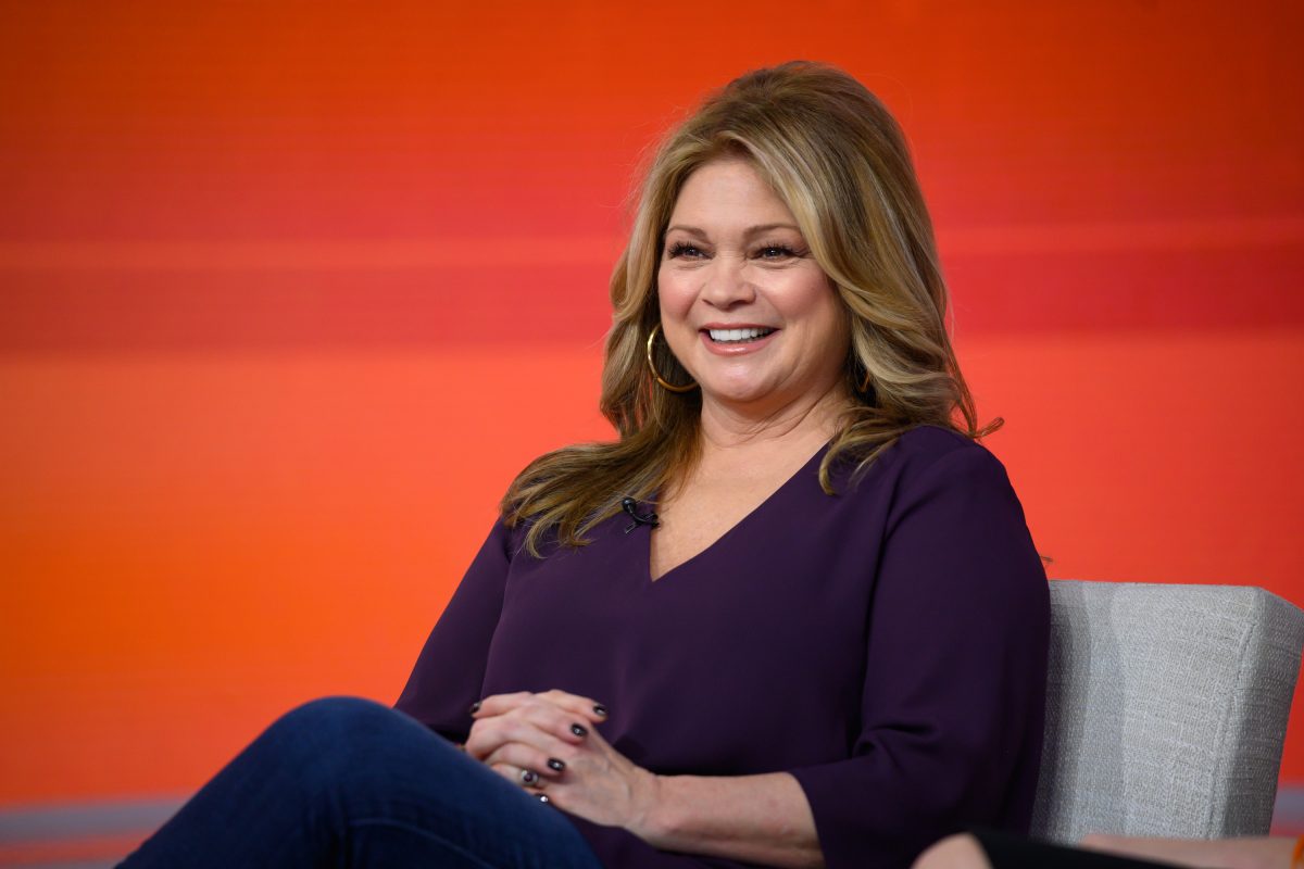 La personnalité de Food Network, Valerie Bertinelli, porte un pull violet à manches longues et à col en V sur cette photo.