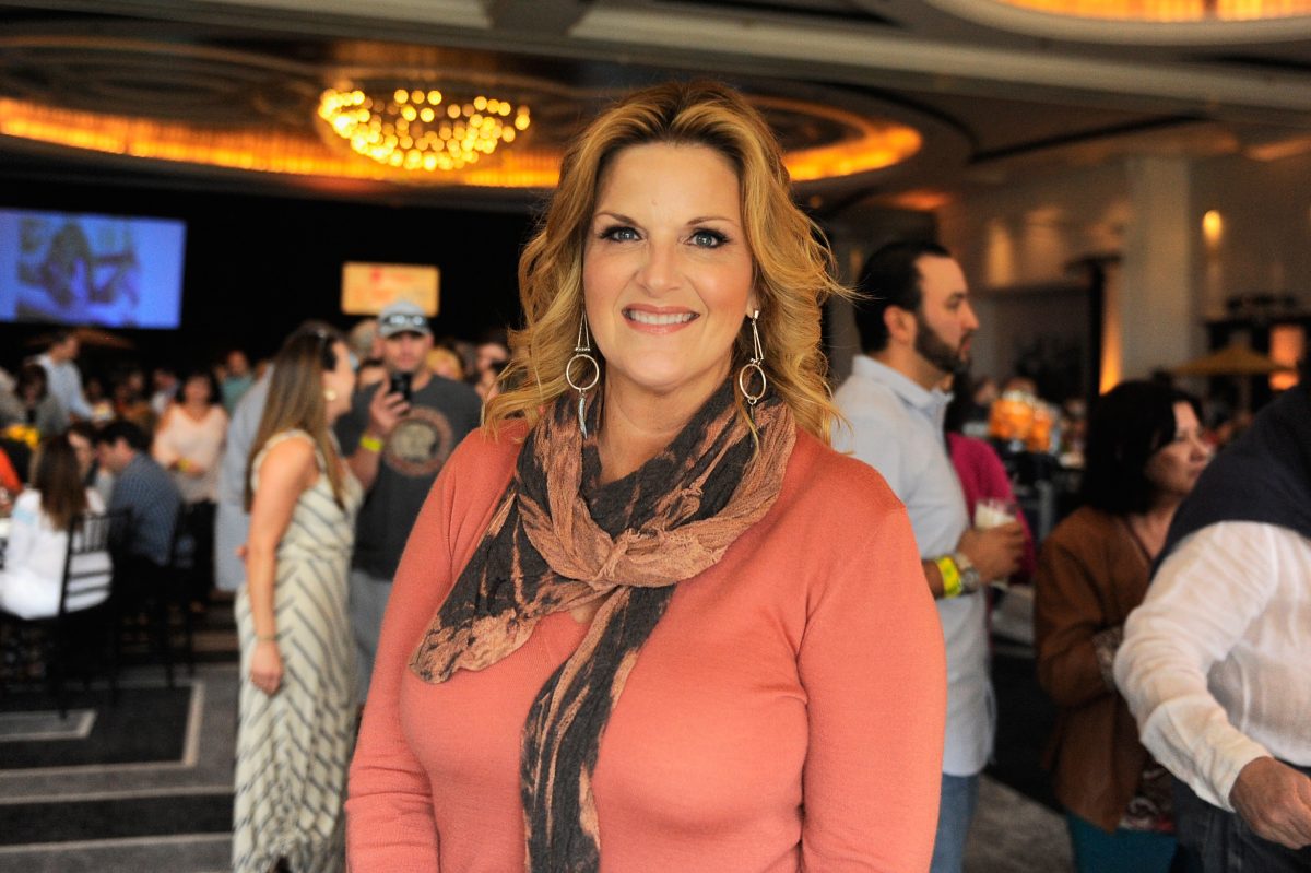 La personnalité de Food Network, Trisha Yearwood, porte un haut à manches longues de couleur saumon sur cette photo.