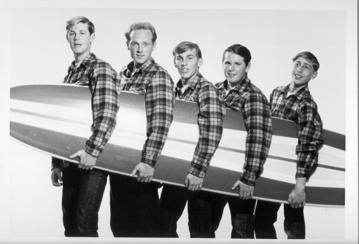 Les Beach Boys tenant une planche de surf
