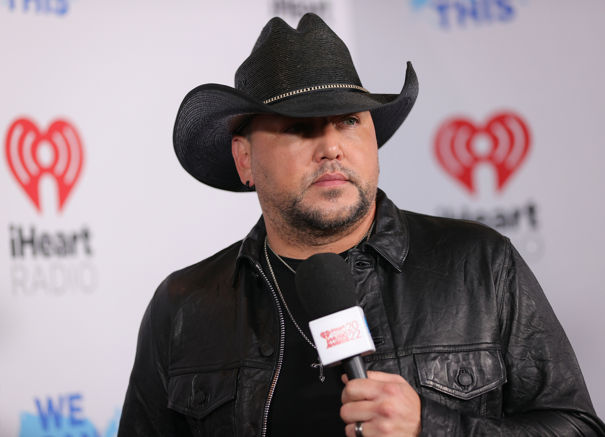 Coiffé d'un chapeau de cowboy noir, Jason Aldean pose pour les photographes aux iHeartRadio Music Awards 2022 à Los Angeles.