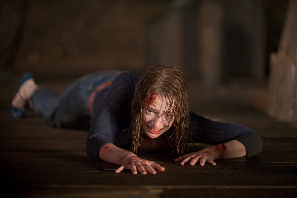 Kristen Connolly joue le rôle de 'Dana' dans LA CABINE DANS LES BOIS. ramper sur le sol avec du sang qui coule de sa tête