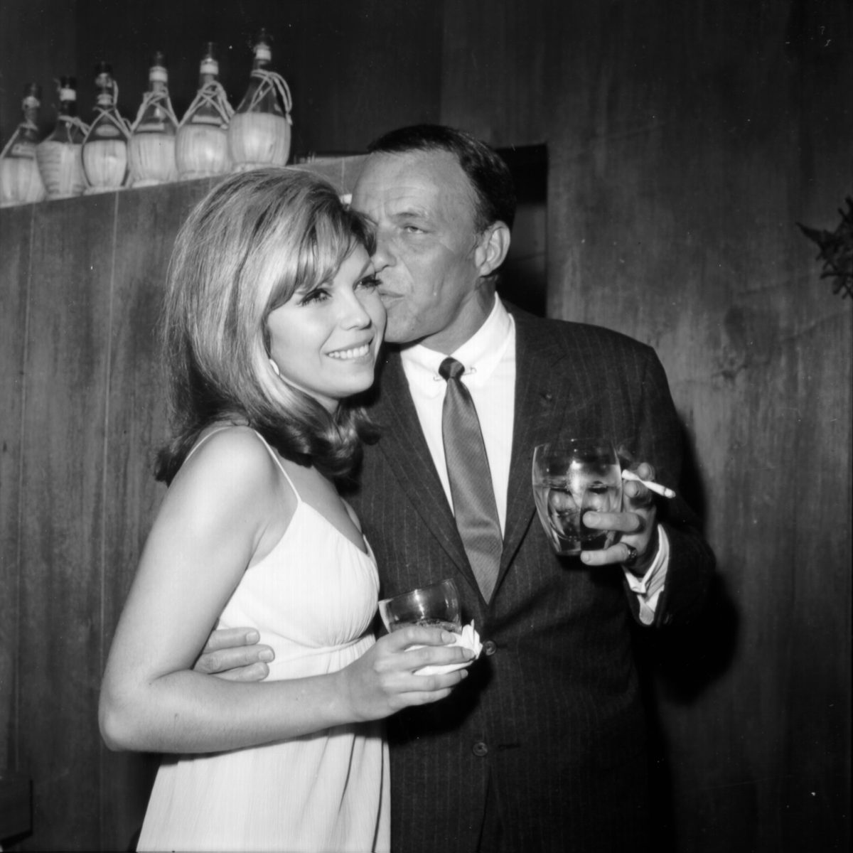 Frank Sinatra embrassant sa fille, Nancy Sinatra, près de quelques bouteilles