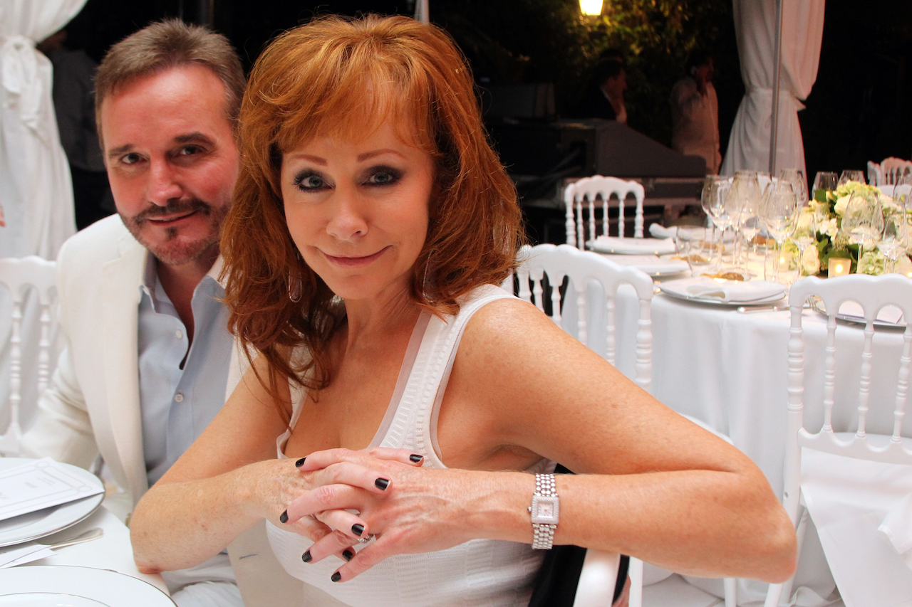 Reba McEntire et Narvel Blackstock, tous deux en blanc et assis à une table