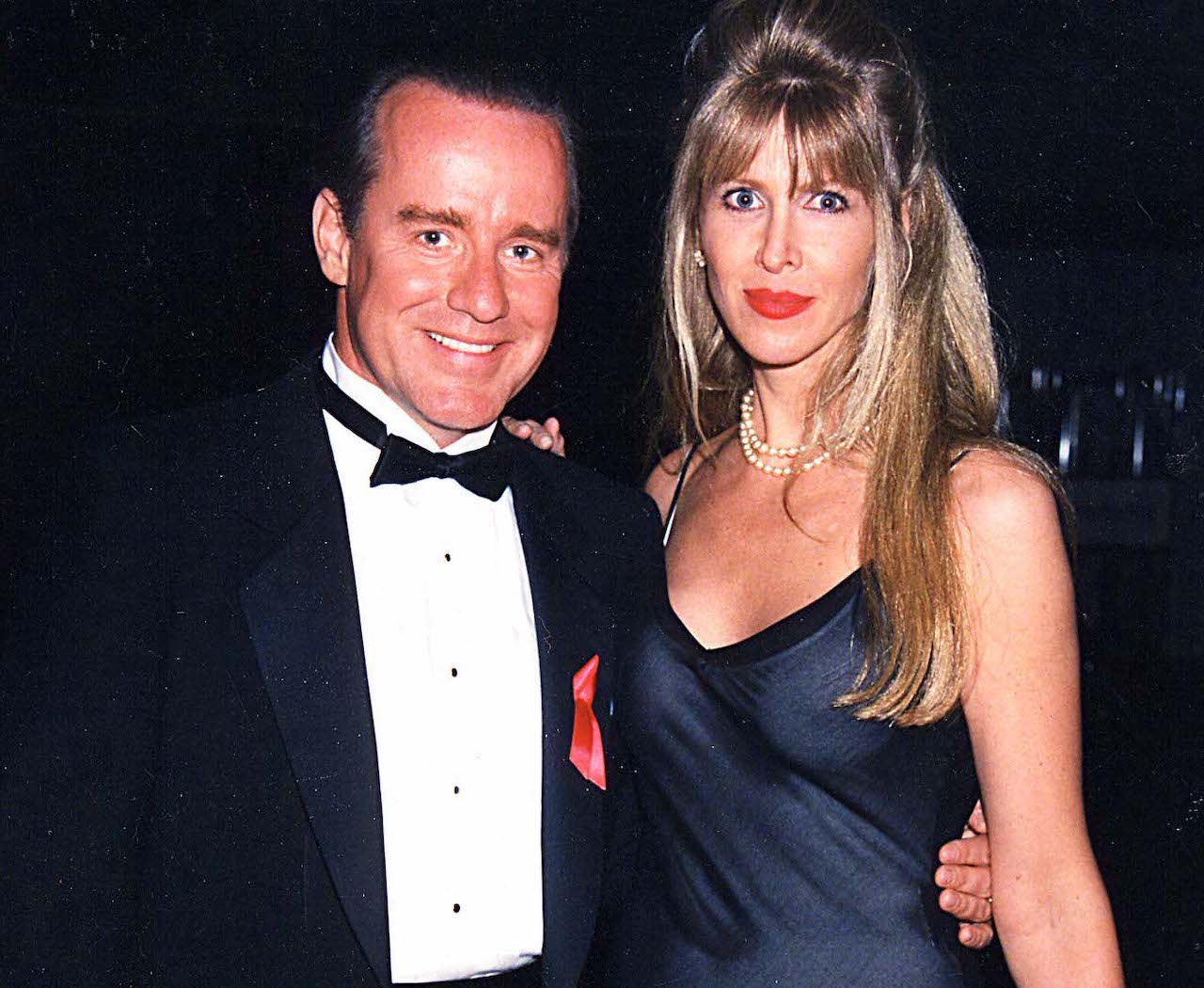 Phil Hartman en smoking, debout avec sa femme, Brynn, en robe noire