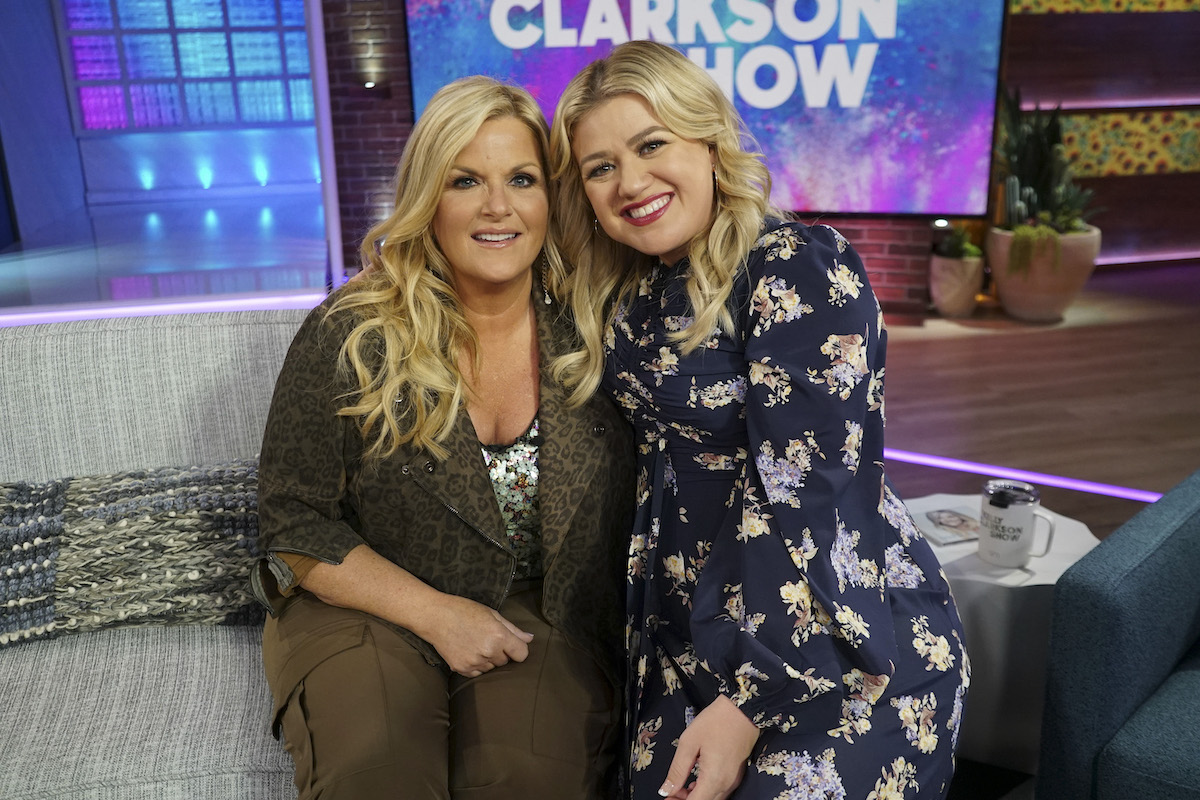 Trisha Yearwood et Kelly Clarkson sourient alors qu'elles sont assises l'une à côté de l'autre sur le tournage de la saison 1 de