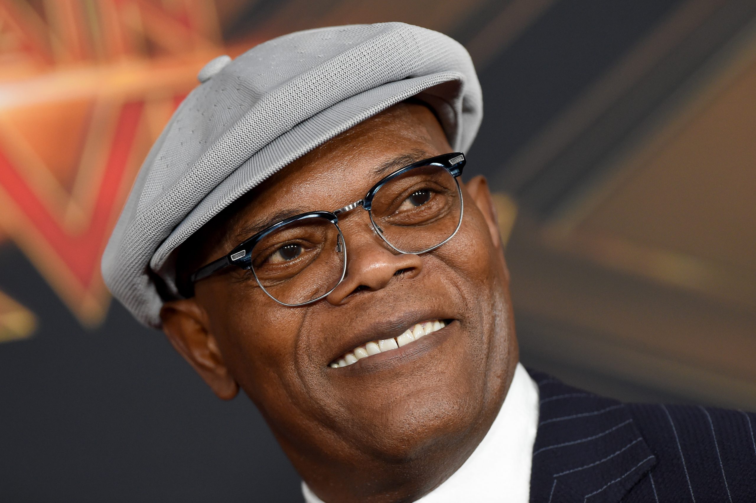Samuel L. Jackson portant un chapeau et un costume gris et assistant à un événement Marvel pour son rôle de Nick Fury.